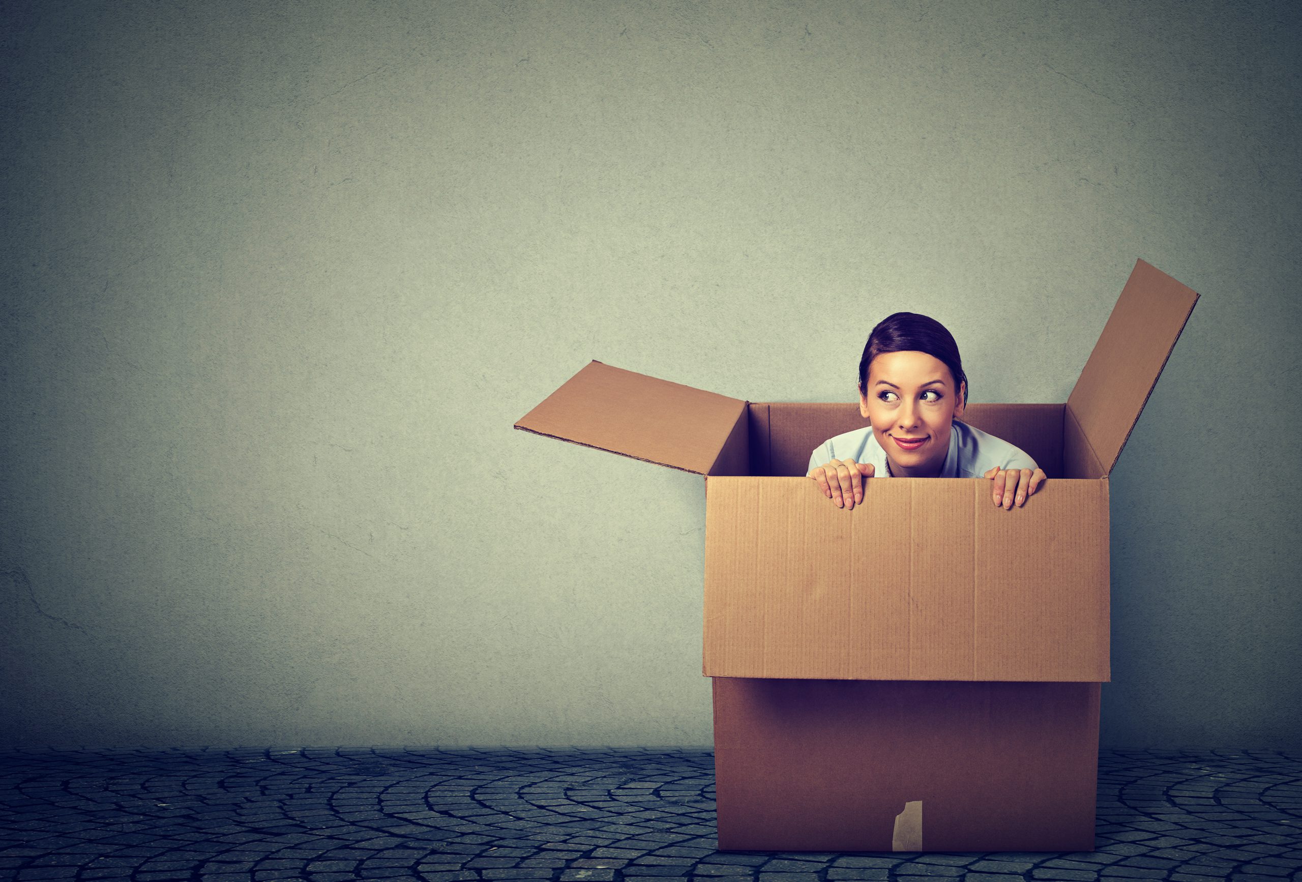 Young woman coming out from a box