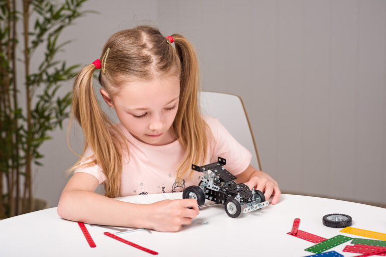 Holčička si hraje se stavebnicí Merkur