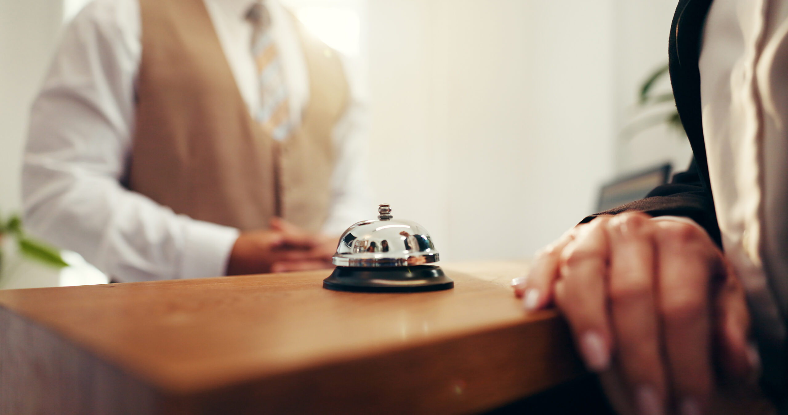 Customer, hands and concierge with service bell for request assistance or help in hotel